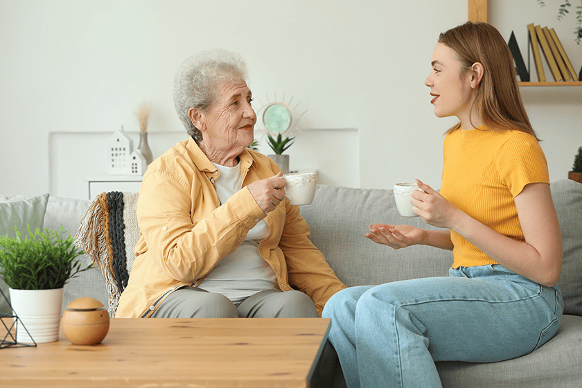 young woman and her grandmother having a sweet conversation with a cup of tea